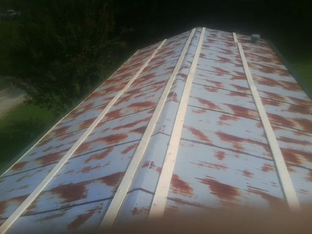 Rusted metal roof panels with new wood purlins before replacement — Storm Damage Roof Repair in Nichols by Roofing Brothers